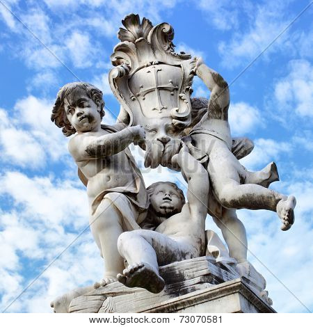 The statue of angels with embleb od the city on Square of Miracles in Pisa near Leaning Tower, Italy 