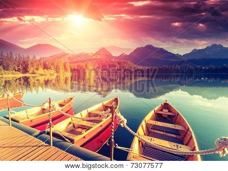Majestic mountain lake in National Park High Tatra. Dramatic unusual scene. Sky glowing by sunlight. Strbske pleso, Slovakia, Europe. Beauty world. Retro style filter. Instagram toning effect.