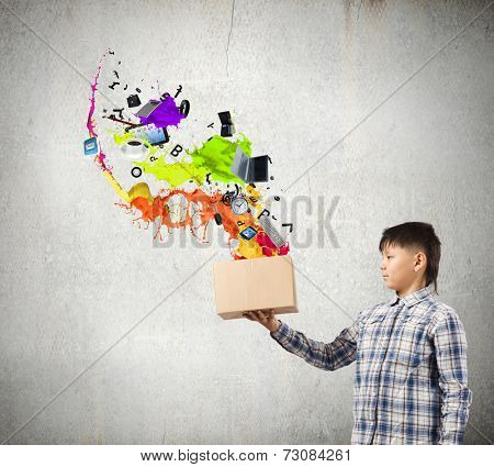 Young boy splashing colorful paint from carton box