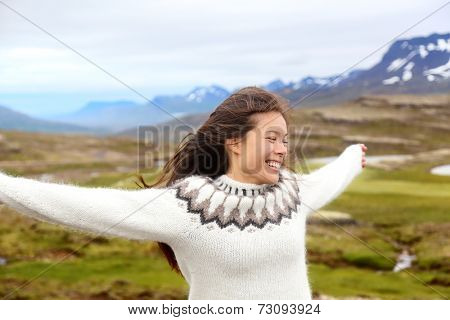 Happy free woman on Iceland in Icelandic sweater. Portrait of girl happy smiling outdoors in nature wearing Icelandic sweater. Pretty Asian Caucasian multiracial female model
