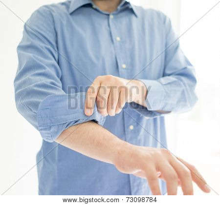 Businessman rolling his sleeves ready to work