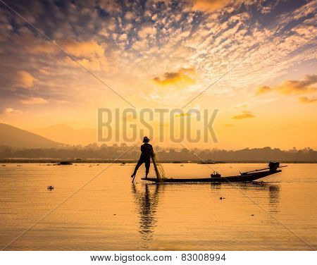 Myanmar travel attraction landmark - traditional Burmese fisherman sihouettes at Inle lake on sunset, Myanmar famous for their distinctive one legged rowing style