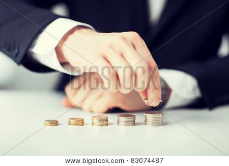 picture of man putting stack of coins into one row