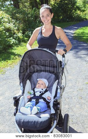 A Young mother jogging with a baby buggy