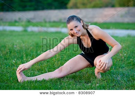 Cute adolescente s'étend ses jambes sur une grasss vert