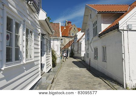 Tourist walks by the street of the old town in Stavanger, Norway.