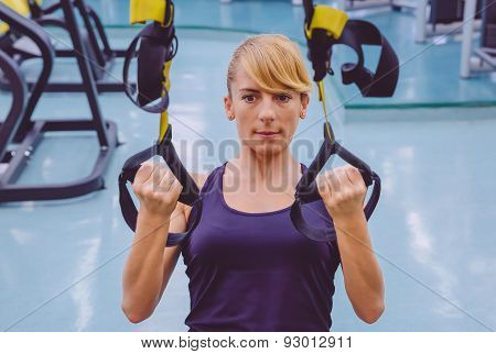 Woman doing suspension training with fitness straps