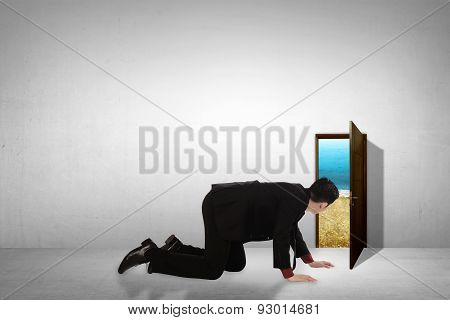 Business Man Take Peek On Small Door Through Beach