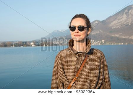 Beautiful woman on a background of lake and mountains.