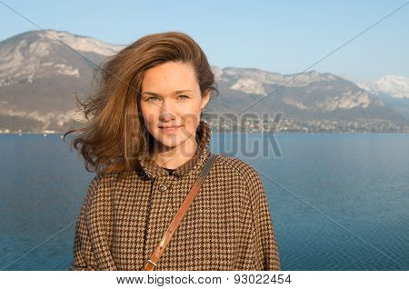 Beautiful woman on a background of lake and mountains.