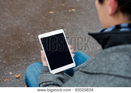 Digital tablet with isolated screen in male hands.
