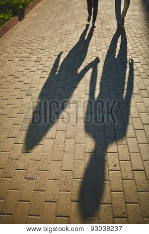 Shadows of amorous dates walking down trottoire