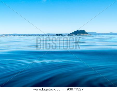 Mount Maunganui on horizon, over sea, with Kaimai range behind.