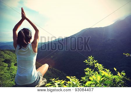 young yoga woman at sunrise mountain peak