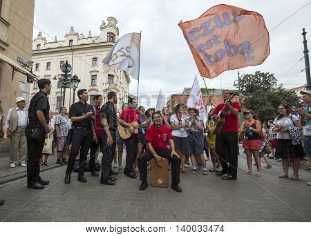 CRACOW POLAND - JULY 24 2016: Pilgrims of World Youth Day sing and dance on the Main Square in Cracow. Poland
