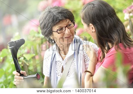 Senior woman with home carer sitting in park