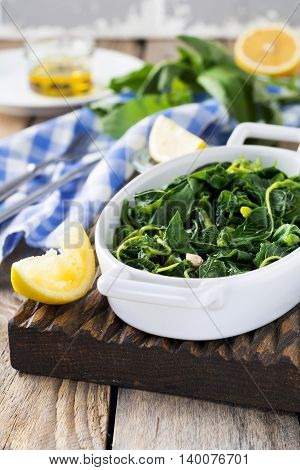 Boiled wild herbs Vlito with lemon juice and olive oil. The traditional Greek snack. Selective focus.