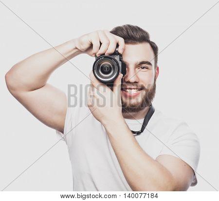 young bearded photographer taking pictures with digital camera.