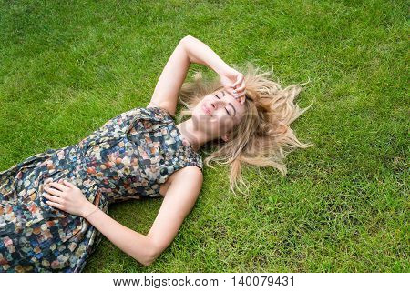 Young Woman Relaxing On A Beautiful Green Meadow.