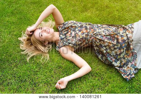 Young Woman Relaxing On A Beautiful Green Meadow.