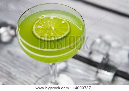 Glass with green cocktail. Slice of lime. Daiquiri with sour juice. Recipe that requires fresh fruit.