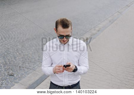 A man walks down the street with the phone and headset