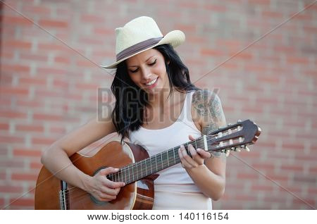 Brunette pretty woman playing a clasic guitar 