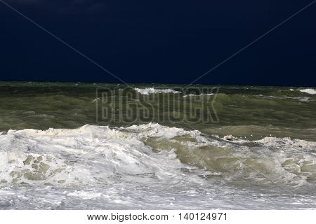 Stormy sea with waves und a dark blue sky.