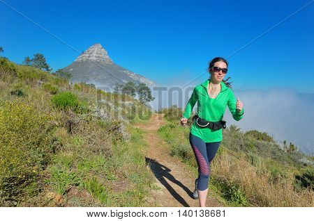 Active woman runner runs trail near Table mountain, Cape Town, South Africa. Running and fitness concept