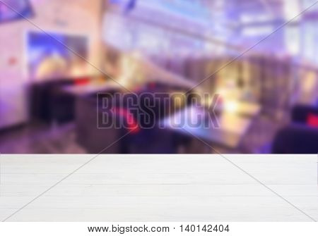 White ooden board empty table in front of blurred background. Perspective whitewood over blur in cafe interior - can be used for display or montage your products. Mockup your products