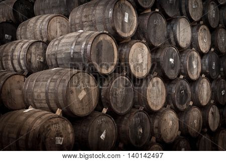 Wine barrels stacked in the old cellar of the winery.