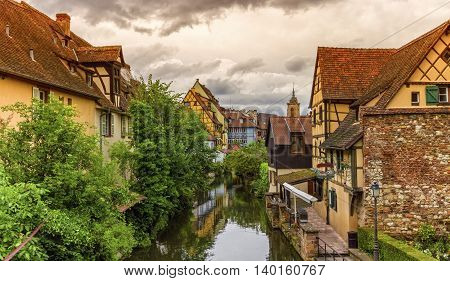 Famous traditional colorful timbered houses in Little Venice, petite Venise and tower of the church, Colmar, Alsace, France