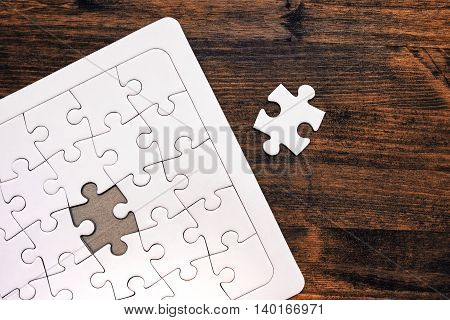 Jigsaw puzzle with one missing piece left to complete copy space top view