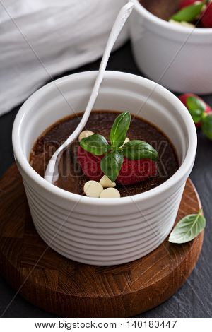Chocolate pudding with raspberries and basil baked in ramekins