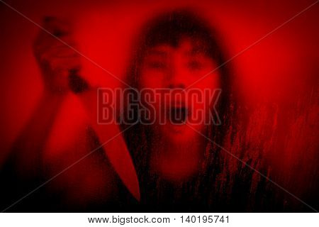 Horror scene of woman with knife behind stained or dirty window glass,Serial killer or violence concept backgroun