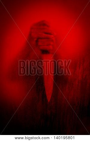 Horror scene of woman with knife behind stained or dirty window glass,Serial killer or violence concept background