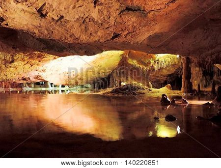 Dripstone cave with subterranean lake and wtaer reflection.
