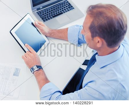 business, office, school and education concept - businessman with tablet pc and papers in office