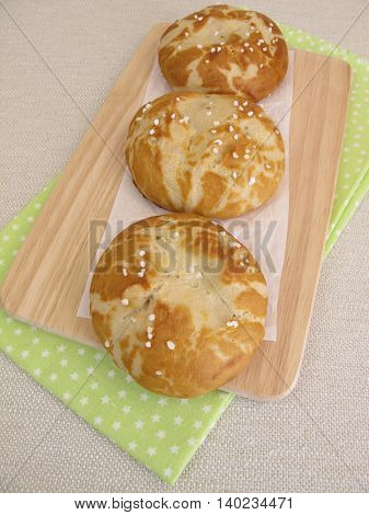 Homemade lye rolls covered with salt on wooden board