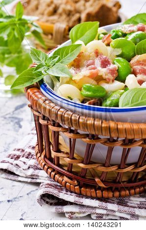 Pasta with bacon and vegetables in portion plate. Selective focus.