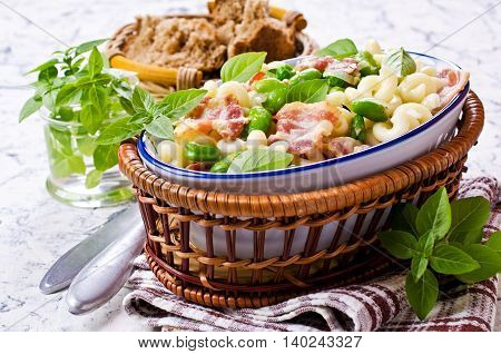 Pasta with bacon and vegetables in portion plate. Selective focus.