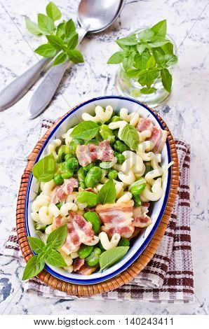Pasta with bacon and vegetables in portion plate. Selective focus.