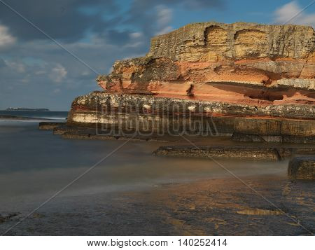 Long exposure shot on amazing pink rocks and sea