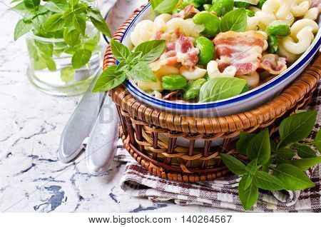 Pasta with bacon and vegetables in portion plate. Selective focus.