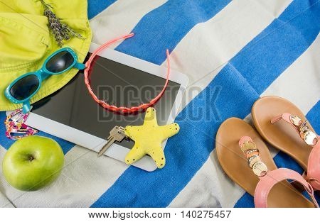 Summer accessories on beach towel top view