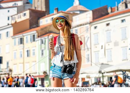 Young female traveler eating ice cream in Piran old town. Traveling in Slovenia