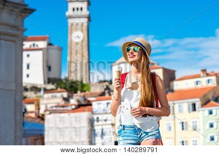 Young female traveler eating ice cream in Piran old town. Traveling in Slovenia
