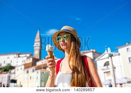 Young female traveler eating ice cream in Piran old town. Traveling in Slovenia