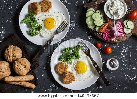 Fried eggs chicken meatballs vegetables and yogurt sauce on a dark background. Healthy lunch or snack