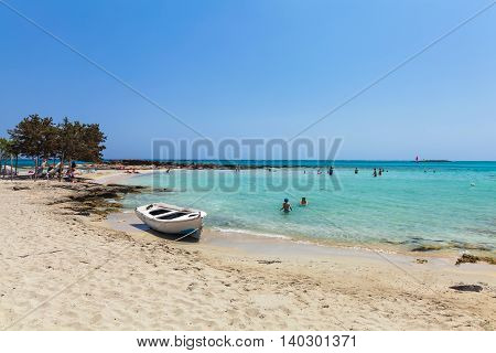 Elafonisi, Island Crete, Greece, - June 26, 2016: The lagoon of beautiful beach of Elafonisi with pink sand, boat and peopleMediterranean Sea)